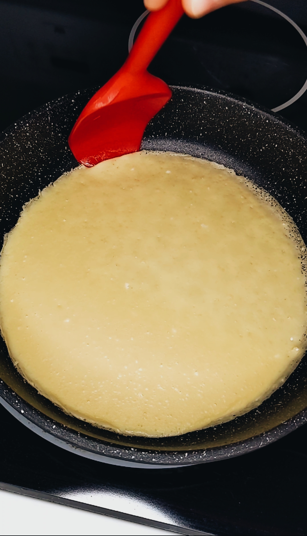 this is how to check the doneness of the crepe. by lifting the edge and unsticking it from the sides, we are able to get beneath the crepe to flip it.